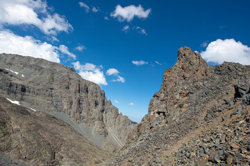 Blue clouds and snow-capped mountains. The Kaçkar Mountains covered in snow. Hiking in the snowy mountains. Walking towards the snowy mountains. Kaçkar Summit. Artvin, Türkiye.
