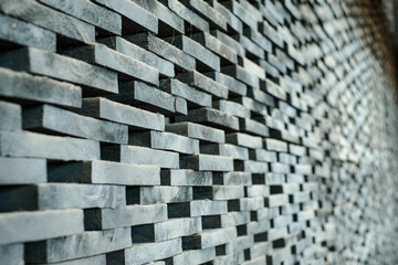 Blur image of dark stacked stone blocks with natural rough patterns, perfect for backgrounds, architectural visuals, and modern graphic design projects