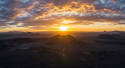 Dramatic sunset over mountains with golden sunlight and cloudscape