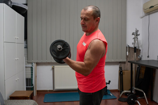 Man doing bicep curls with dumbbell - Powered by Adobe