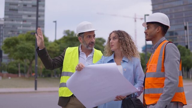 Construction team examining blueprints at building site