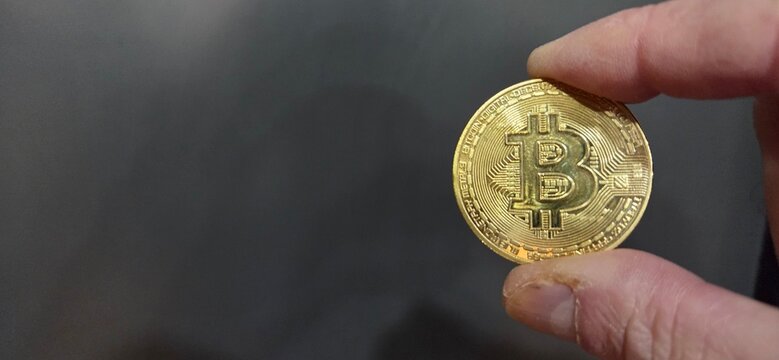 Mano mostrando monedas de Bitcoin