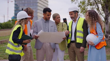 Diverse team of architects and engineers discussing building blueprints on a construction site - Powered by Adobe