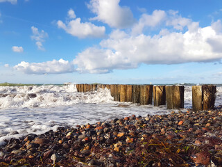 wooden pier on the beach at the baltic sea with waves