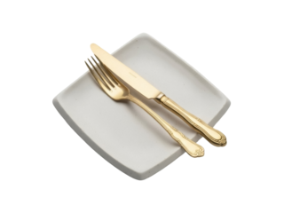 Isolated flatware set with golden knife and fork resting on a grey square ceramic plate