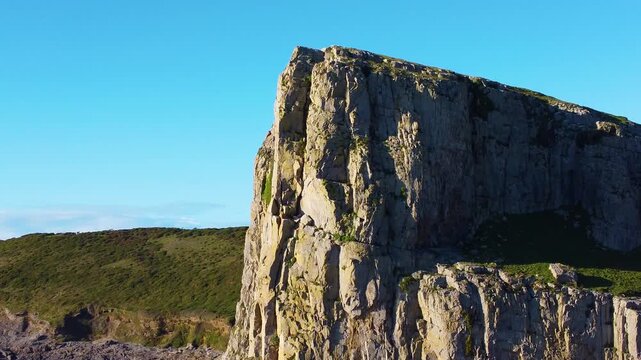 Large Sheer Cliff near Fall Bay on Gower Coast. Beautiful Natural Dramatic Coastal Mountain. Orbiting Aerial Drone. Popular Tourist Holiday Destination in Wales, UK.