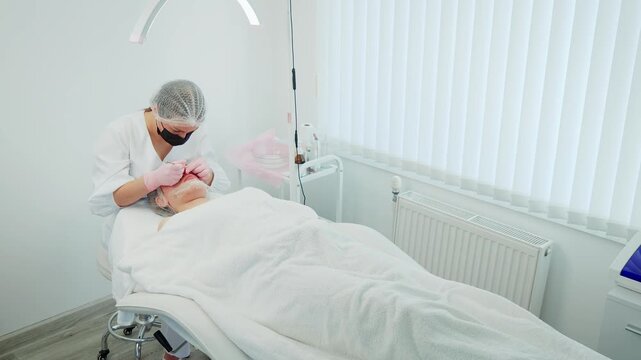 Girl patient in beauty clinic undergoing skincare procedure and acne removal. Female client in cosmetic center receiving skin treatment and blackhead extraction. Woman undergoing facial care and acne