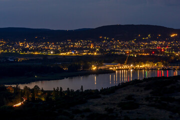 Illuminated village at night by the lake, view of Lake Balaton from the Tihany lookout in Hungary.