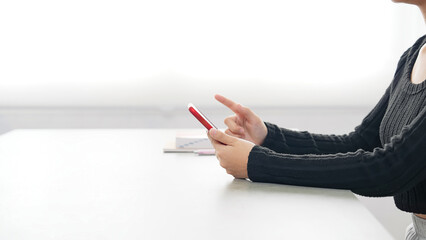 A woman using a smartphone in her room