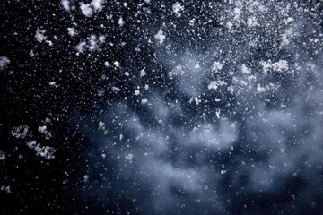 Obraz premium A dark, blurry close-up showcases falling snowflakes, with light reflecting off them in the air