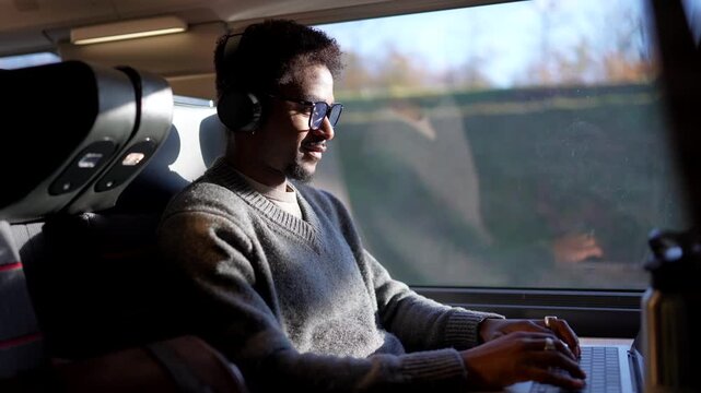 Focused african american businessman working on laptop during train trip