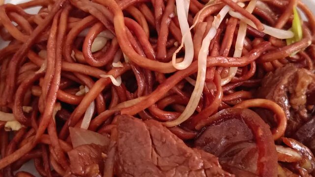B&oelig;uf aux oignons servi avec nouilles saut&eacute;es en gros plan app&eacute;tissant
