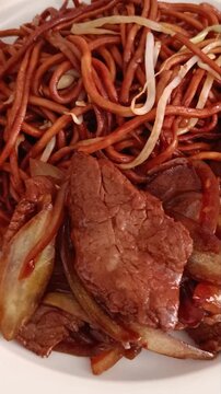 B&oelig;uf aux oignons servi avec nouilles saut&eacute;es en gros plan app&eacute;tissant