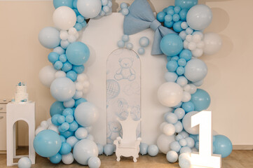 Arch is decorated with blue, white balloons. Baby one party. Trendy arch for boy 1 year. Reception at a birthday party. Celebration concept. Birthday Cake on a background decor. Delicious reception.