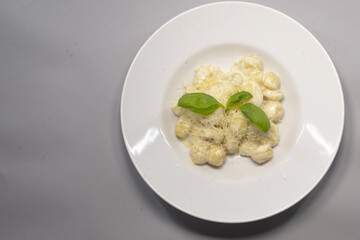Food blogging. White plate with food placed on a gray background, leaving space for text, reflecting culinary presentation and use in social media.