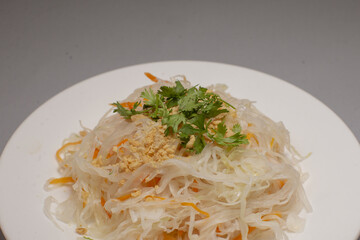 This dish features shredded cabbage, orange carrots, crunchy peanuts, and fresh cilantro for added flavor