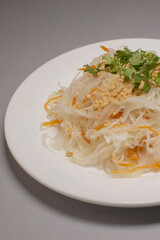 A delicious plate of noodles with colorful vegetables and fragrant herbs, a popular Asian dish with delightful flavors