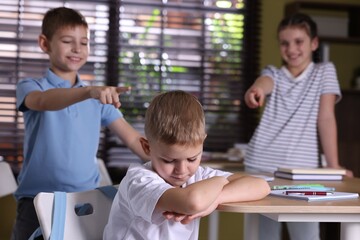 Obraz premium Boy getting bullied by his classmates in school, selective focus