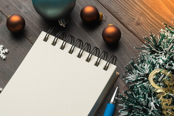 Christmas decorations and blank notebook on wooden table for holiday planning