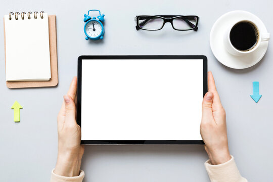Close up image woman hands holding digital tablet with blank copy space screen for your text message or promotional content om table with cup of coffee. hands of a woman holding blank tablet device
