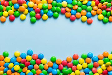 Mixed collection of colorful candy, on colored background. Flat lay, top view. frame of colorful chocolate coated candy