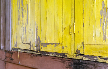 Peeling yellow painted wood combined with aged timber, creating a rustic vintage texture. Ideal for backgrounds and natural, distressed design themes