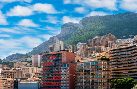 cityscape sunset view of a Monte Carlo city in Monako with high buildings, tall skyscrapers and industrial landscape with evening mountains on background