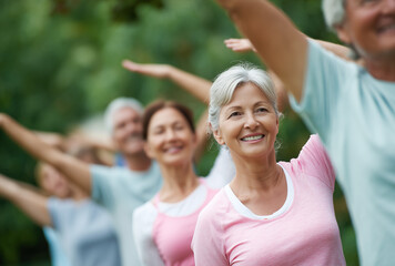 People participate in outdoor exercise class for fitness and social interaction in a park setting during sunny day