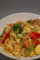 A delicious plate of fettuccine noodles accompanied by a mix of colorful vegetables and savory sauce