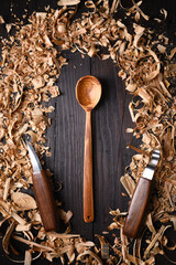 Handcrafted wooden spoon with heap of wooden filings with hand carpentry tools. Handcrafting concept