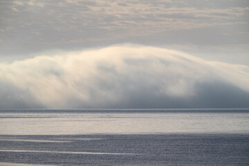 Fog bank rolling over calm sea