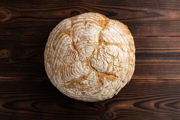 bread with a golden brown, crispy crust, featuring deep and even slashes on the wooden surface