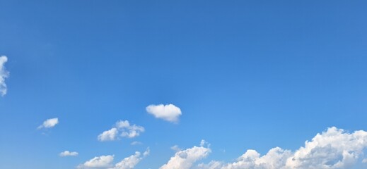 Beautiful blue sky with fluffy white clouds and copy space for background