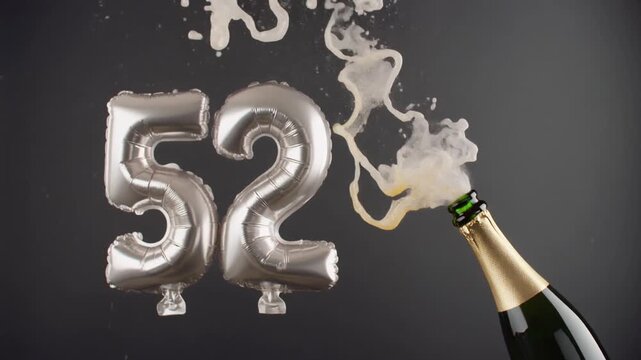 Number 52 balloon with popping champagne bottle. Celebrating a milestone, anniversary or birthday