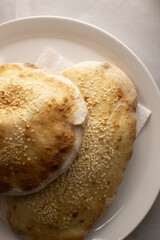Artisan flatbreads arranged aesthetically, Warm tones highlight crispy seedtopped flatbreads, Closeup of soft sesame bread with crunchy crust on plate