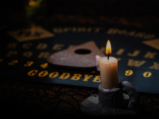 Candle burning with spirt board and pumpkins