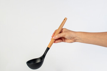 Black plastic spatula in hand on white background
