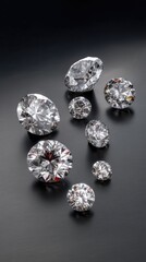 Collection of sparkling diamonds arranged artistically on a dark surface showcasing various cuts and sizes