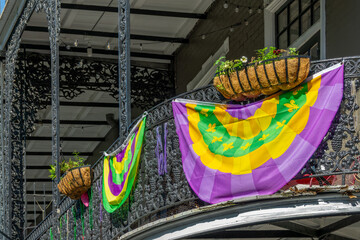 Balconies with intricate ironwork and Mardi Gras banner on a building in a street of the French Quarter, New Orleans architecture, Louisiana © Delphotostock