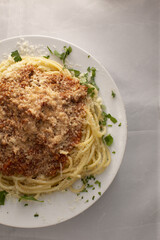 Comfort food presentation, Homestyle pasta with toppings, Classic spaghetti served with herbs and cheese, Cozy homemade spaghetti dish topped with breadcrumbs
