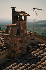 Fototapeta premium chimney silhouettes under sunset light, weathered chimney and village scene in warm late afternoon glow
