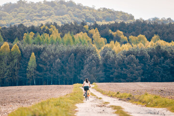 Fototapeta premium Cyclist riding dirt road in countryside