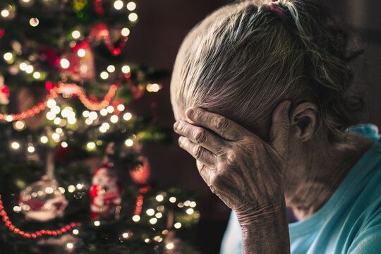 Fototapeta Sad on christmas. Old woman, lonely senior on winter holiday. Depressed elderly on xmas season. Dementia or depression.