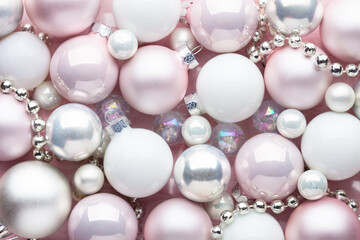 Close-up of a pile of Christmas tree baubles and decorations of varying shades and textures. Flat lay