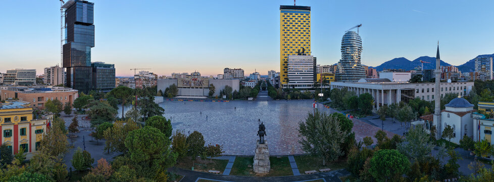 Aerial panorama of Skanderbeg Square at Dawn surrounded by modern towers and city landmarks.