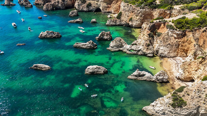 Aerial Drone View of Praia do Vau in Portimao, Portugal with Golden Cliffs, Turquoise Waters and Summer Holiday Boats
