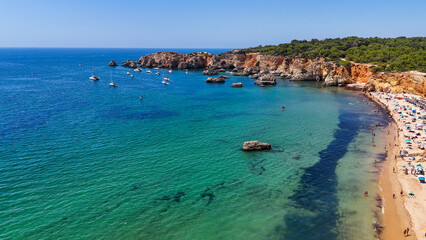 Aerial Drone View of Praia do Vau in Portimao, Portugal with Golden Cliffs, Turquoise Waters and Summer Holiday Boats