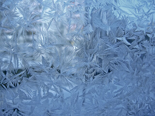 Beautiful ice pattern on window glass, close-up natural winter background