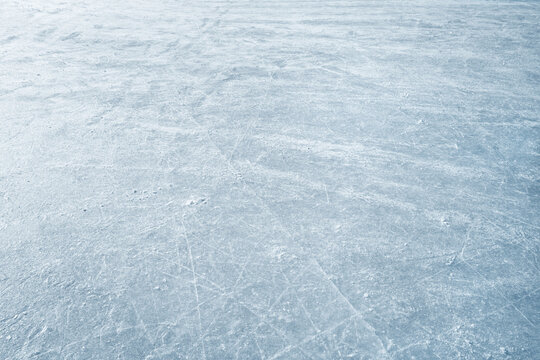 An ice surface as an ice rink with ice skates tracks. Winter sports texture. Poster with copy space.