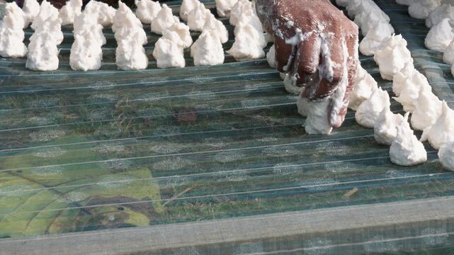 person making Bori, which are traditional sun dried lentil dumplings popular in Bengali cuisine